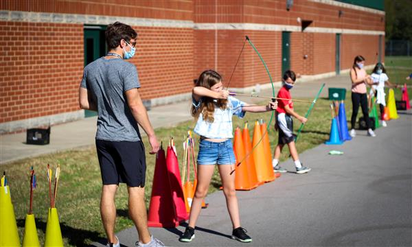 Teacher walks by as girl fires arrow